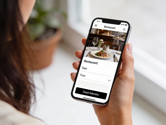 A woman holding her smartphone, browsing and booking a table at a restaurant online, showing the convenience of making reservations digitally