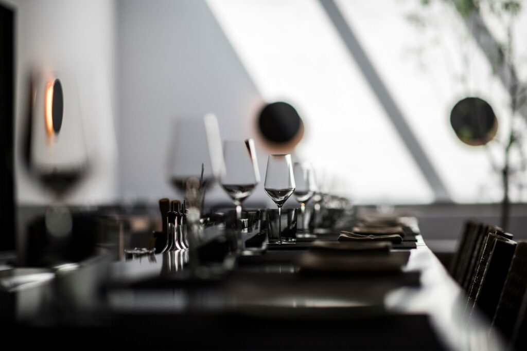 Carefully arranged glasses and ceramic plates on a restaurant table, reflecting attention to detail, material quality, and an elevated dining experience.