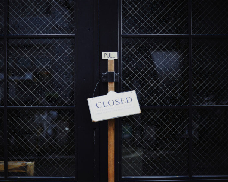 A “Closed” sign hanging on a restaurant door, symbolising a pause in operations or off-hours for the business.