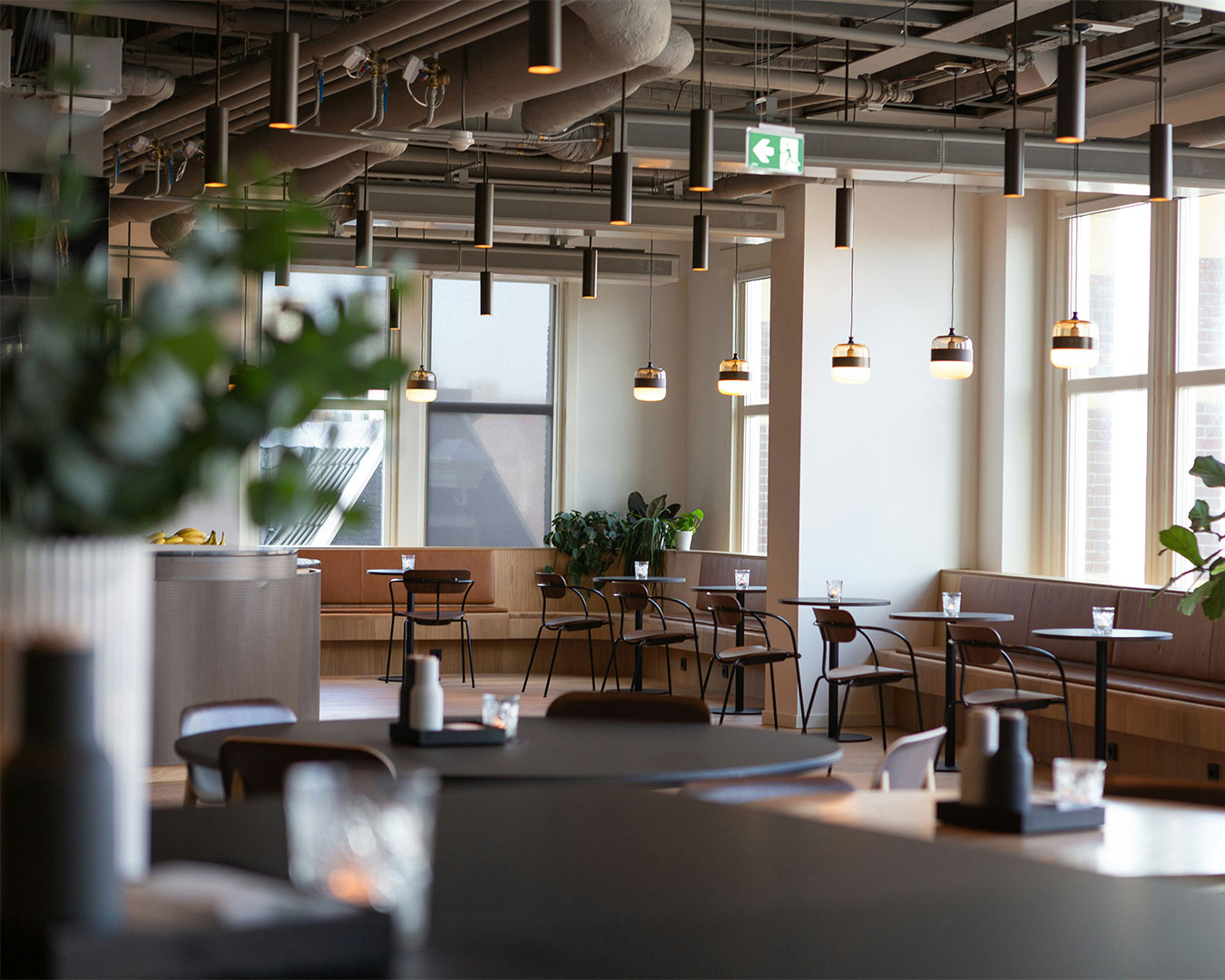 A warm and modern restaurant interior with neatly arranged tables, soft ambient lighting, and subtle decorative elements, creating an inviting atmosphere for diners.
