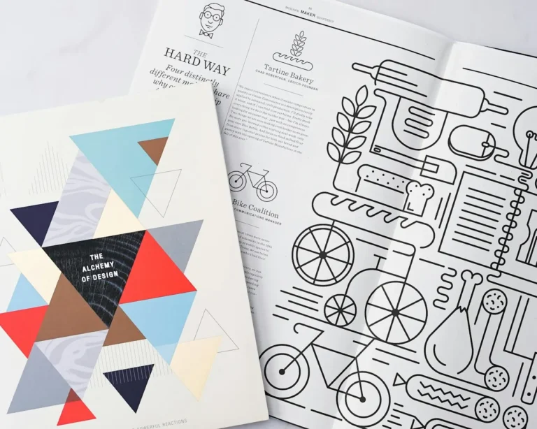 A geometric design booklet with colorful triangles titled "The Alchemy of Design" overlaps a magazine page featuring food-themed line illustrations.