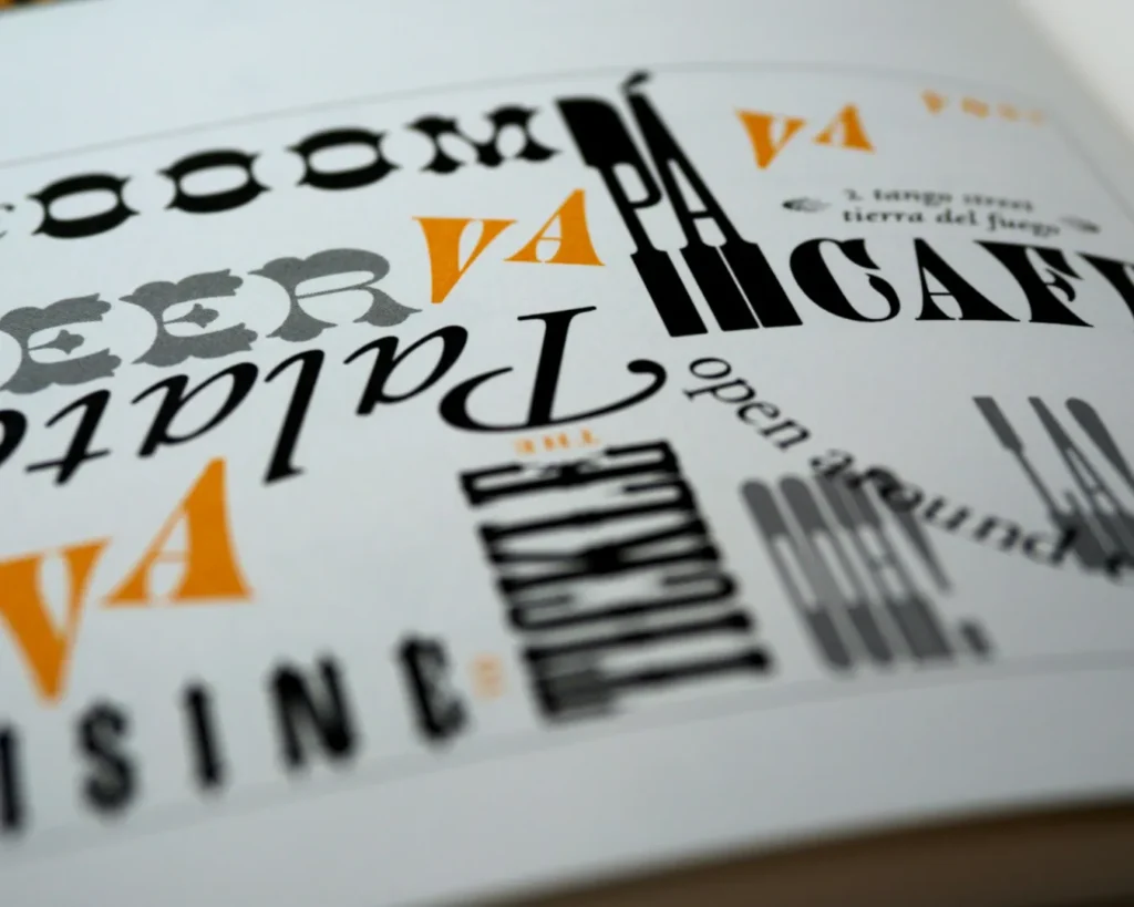 Stylized text scattered across a white page, featuring bold, black, and orange fonts in varied orientations. The design is dynamic and artistic.