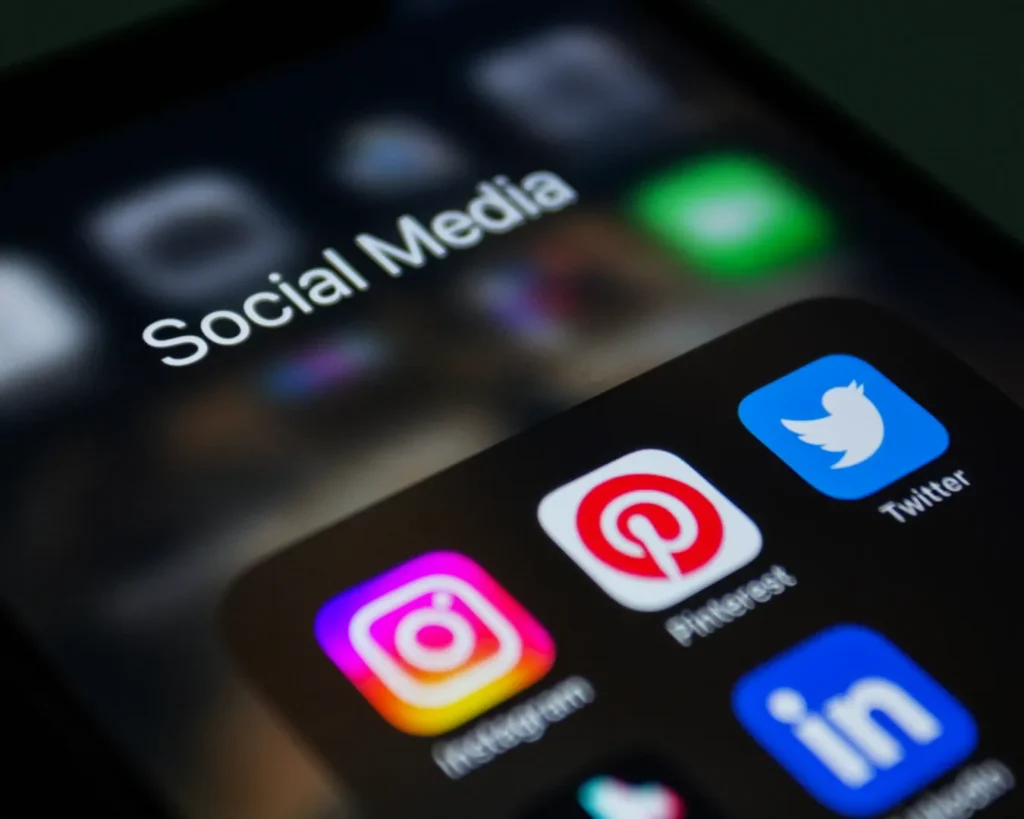 Close-up of a smartphone screen displaying a folder labeled "Social Media." Visible app icons include Instagram, Pinterest, Twitter, and LinkedIn.