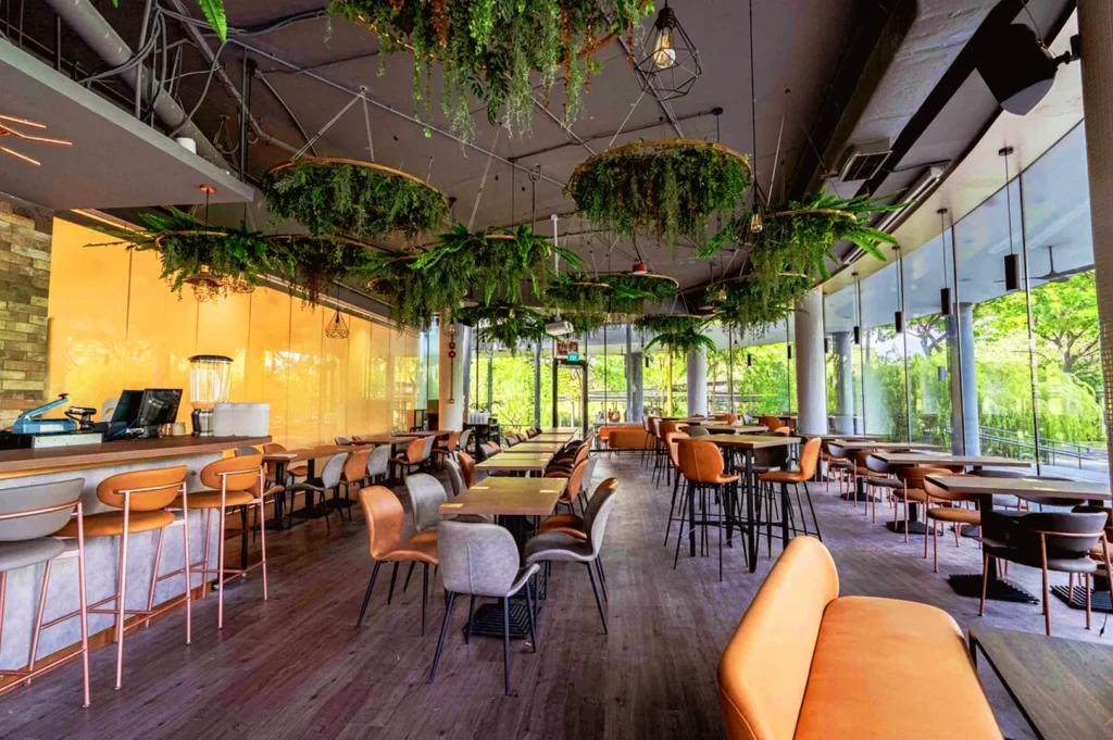 Modern café interior in Singapore with natural lighting and greenery, highlighting restaurant ambiance and brand experience consistency