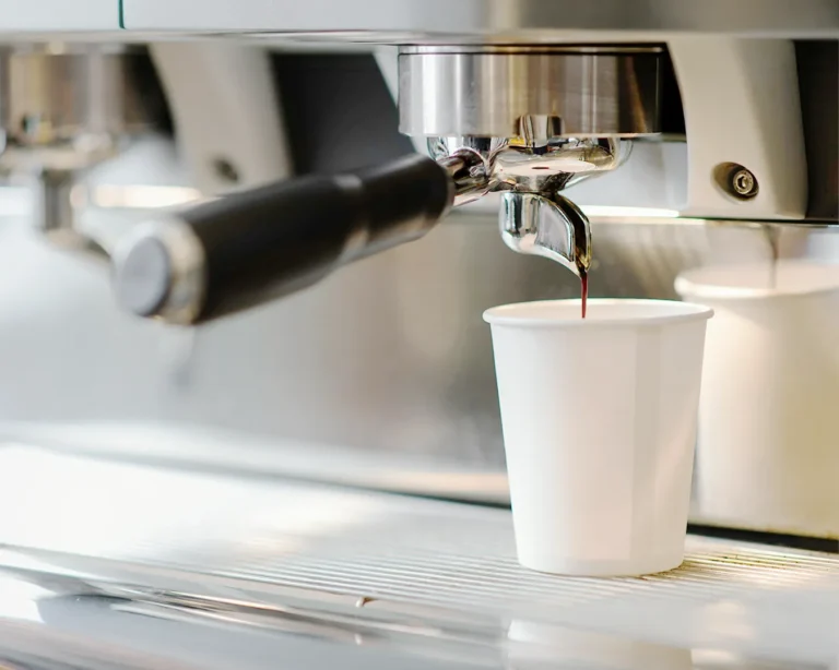 Minimalist restaurant branding cost Singapore concept with espresso machine pouring coffee into blank takeaway cup in modern cafe setting