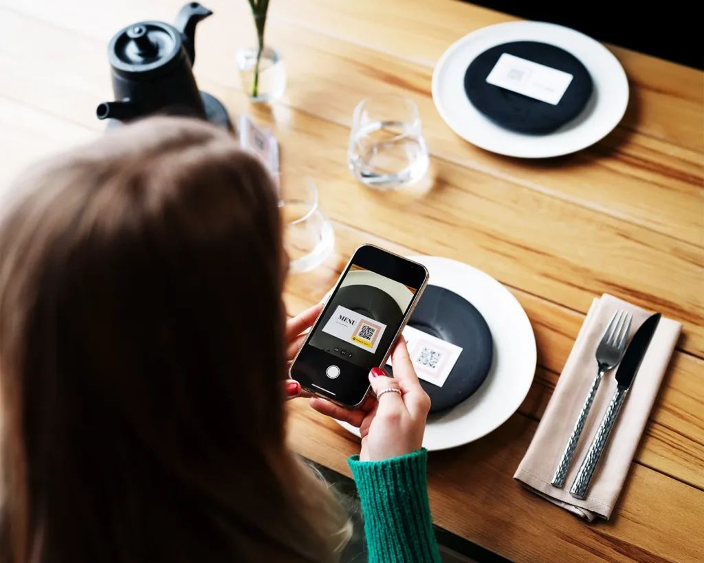 Customer scanning QR code menu at restaurant table in Singapore, showcasing digital ordering system and measurable restaurant marketing conversion