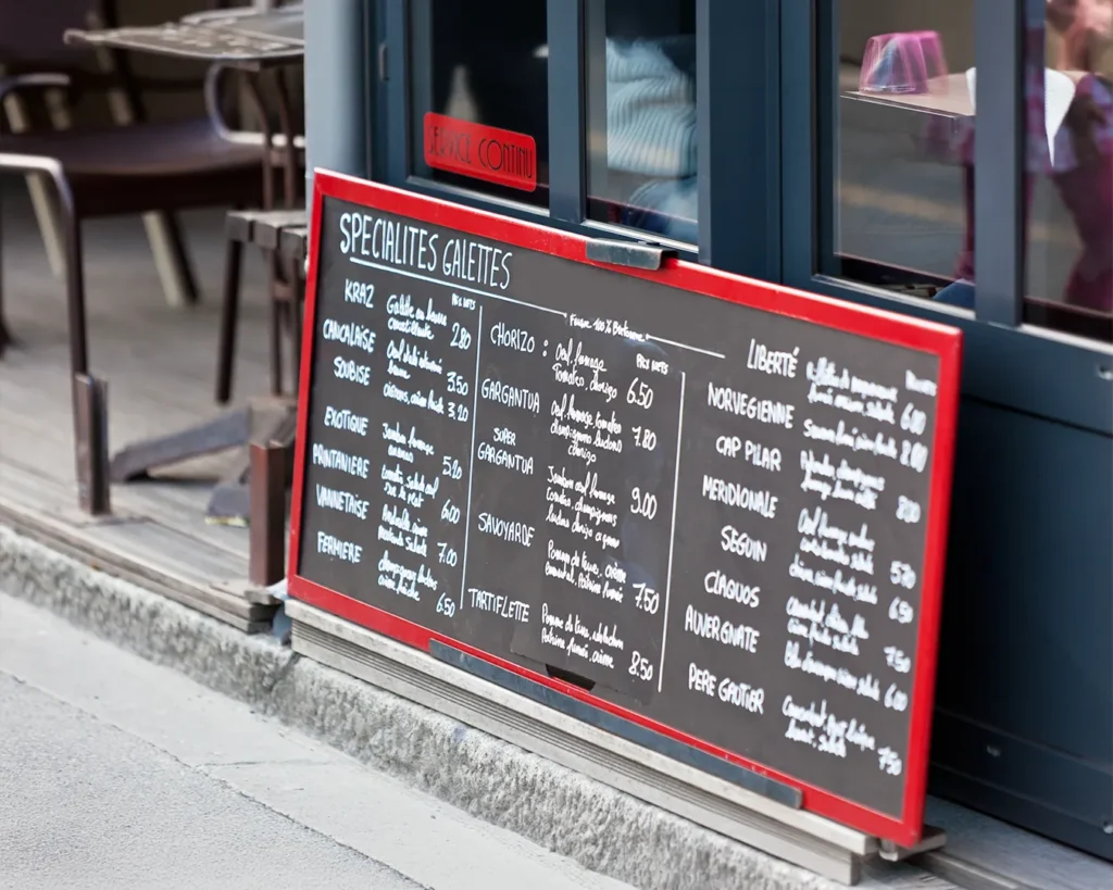 Outdoor restaurant chalkboard menu display with handwritten specials and pricing, illustrating attention-grabbing menu presentation for local restaurants