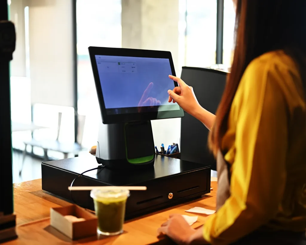 Restaurant POS system checkout with staff using touchscreen, highlighting revenue tracking and performance measurement in Singapore F&B operations