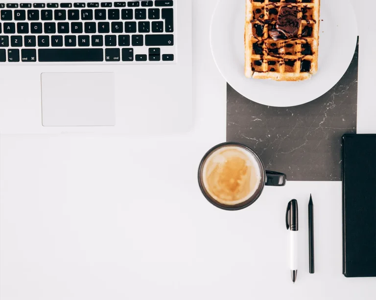 Restaurant branding workspace with laptop, coffee, waffle and notebook, brand consistency strategy, local SEO planning, restaurant digital marketing Singapore