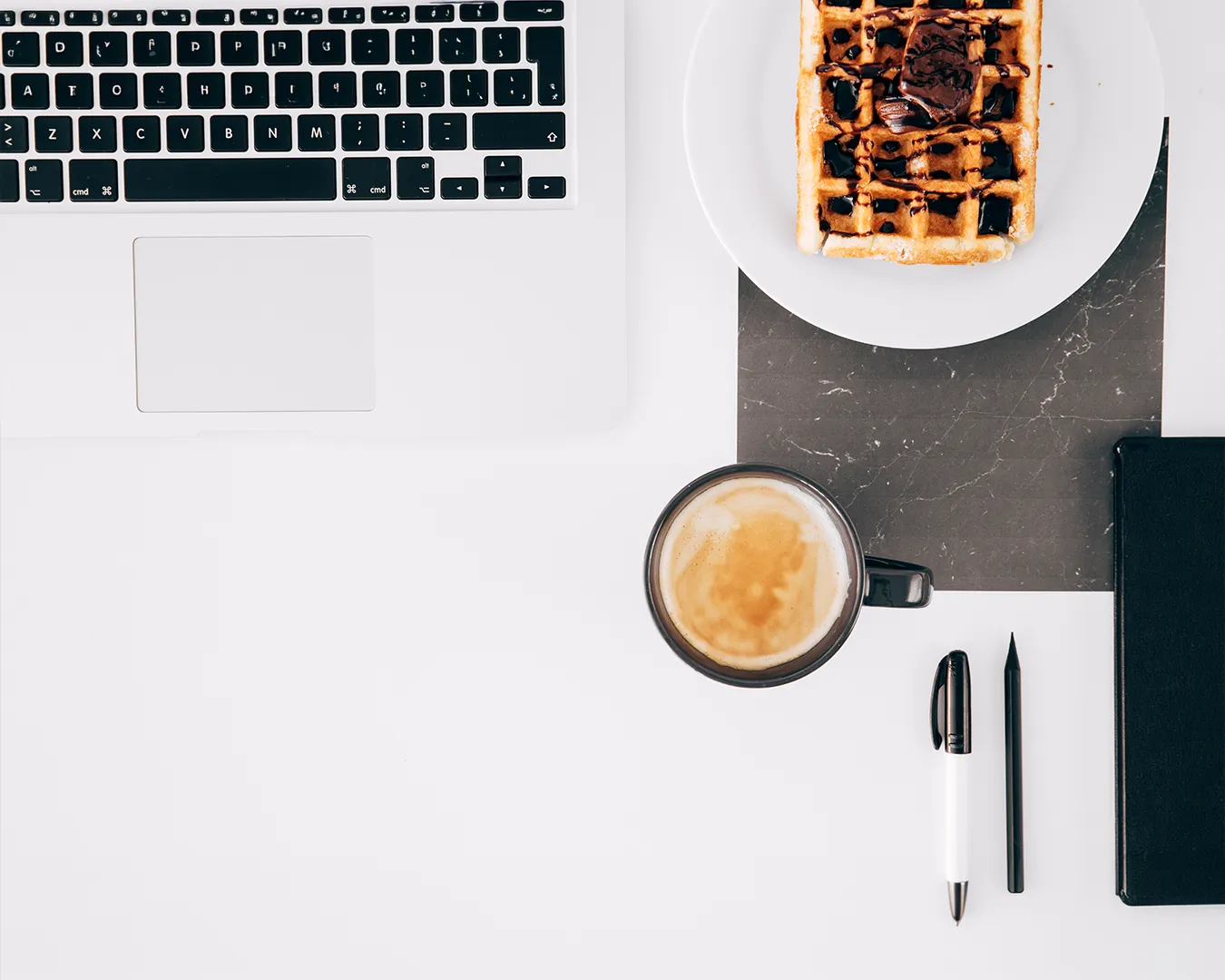 Restaurant branding workspace with laptop, coffee, waffle and notebook, brand consistency strategy, local SEO planning, restaurant digital marketing Singapore
