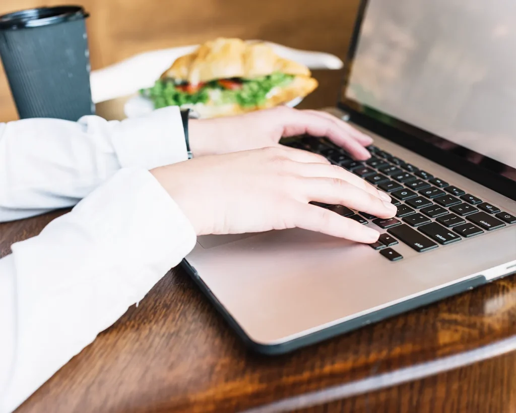 Restaurant owner updating business information on laptop, digital profile management, local search optimization, restaurant brand consistency