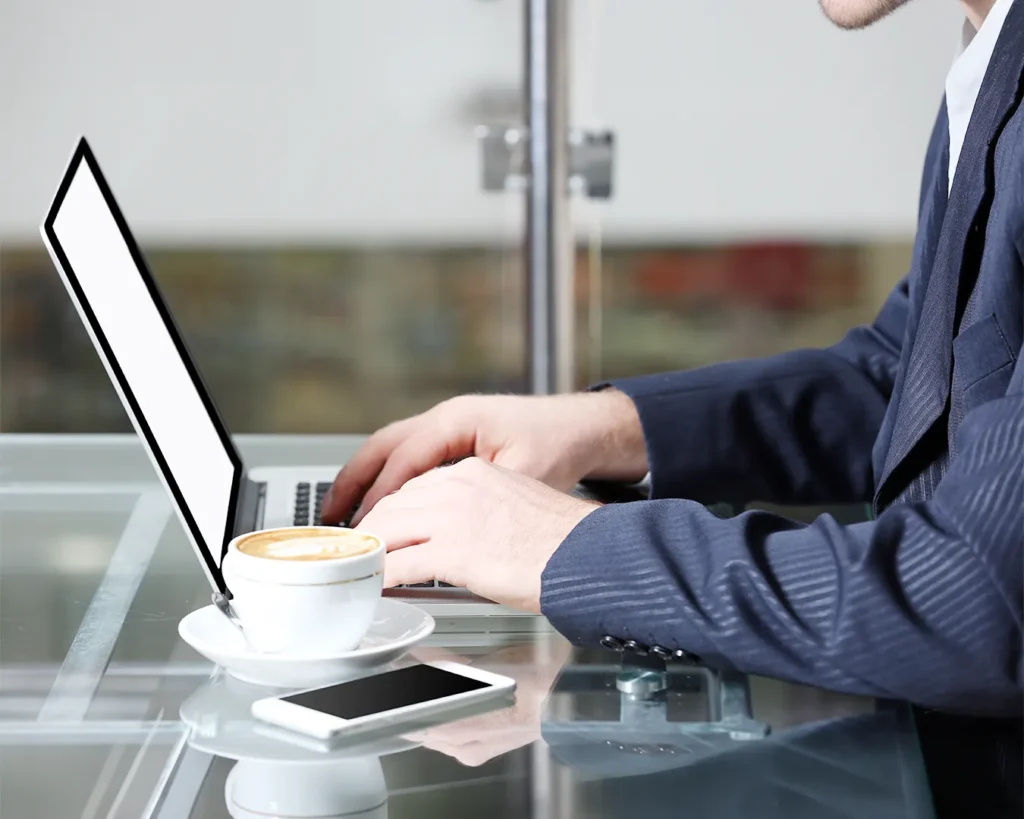 Restaurant professional working on laptop with coffee during restaurant branding strategy planning