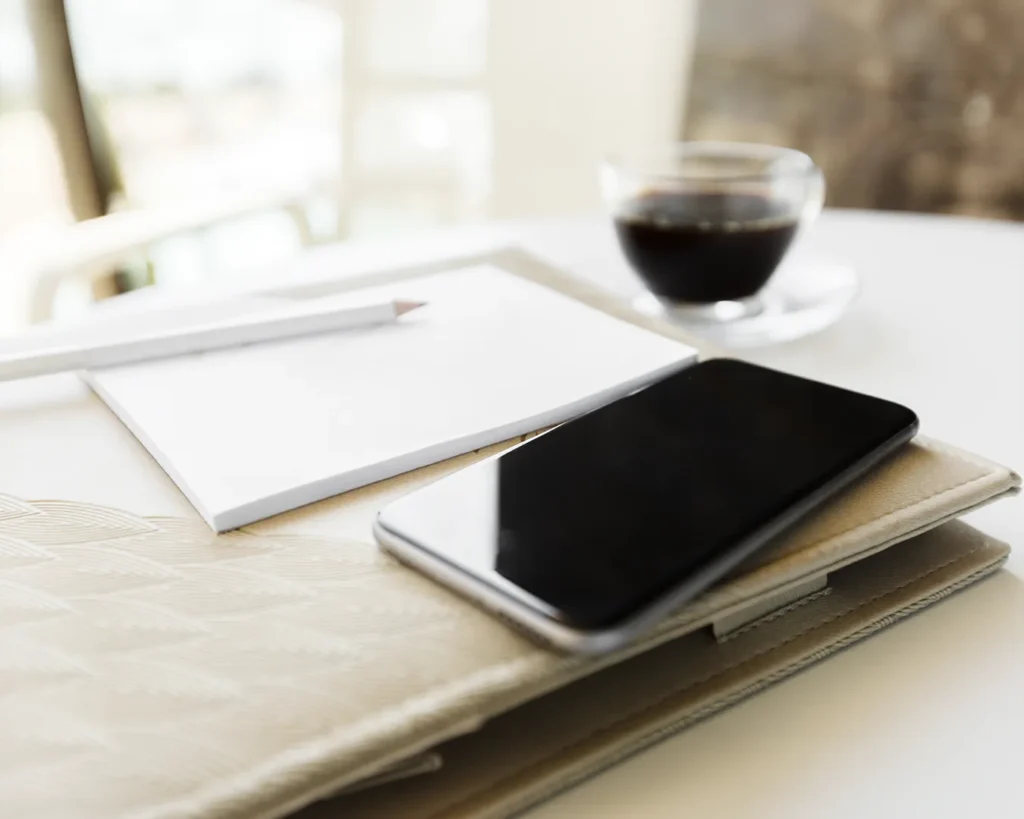 Restaurant marketing strategy workspace with smartphone, notebook and coffee cup