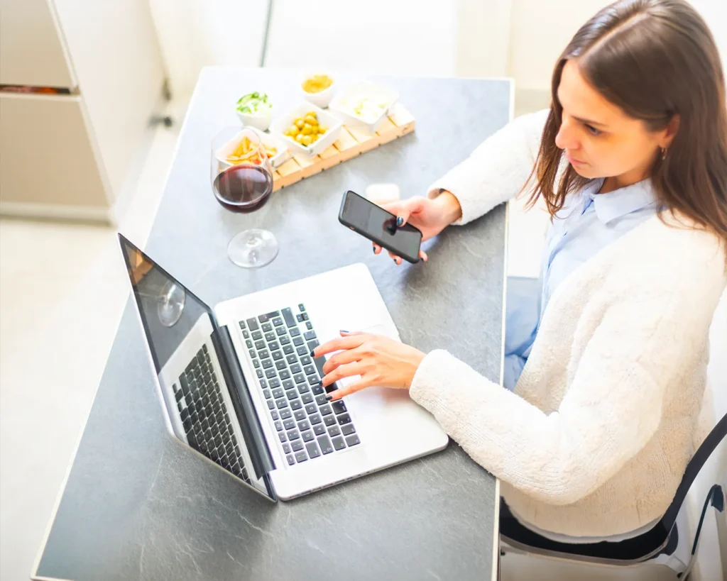 Restaurant manager reviewing digital marketing across laptop and smartphone, brand consistency audit, local search visibility management, restaurant online presence Singapore