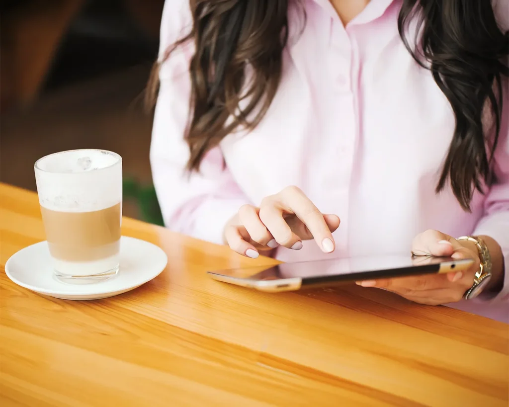 Restaurant owner reviewing website and Instagram content on tablet with coffee, ensuring consistent restaurant branding, online marketing, and customer experience across digital channels.