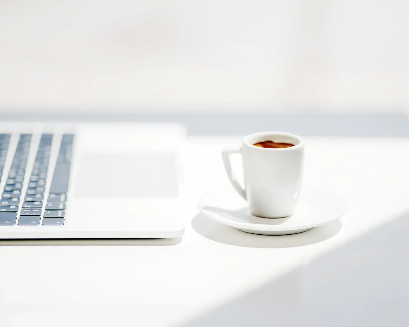 Restaurant local SEO agency Singapore workspace with laptop and espresso on a clean white desk, representing Google Business Profile optimization, local search visibility, and restaurant digital marketing strategy.