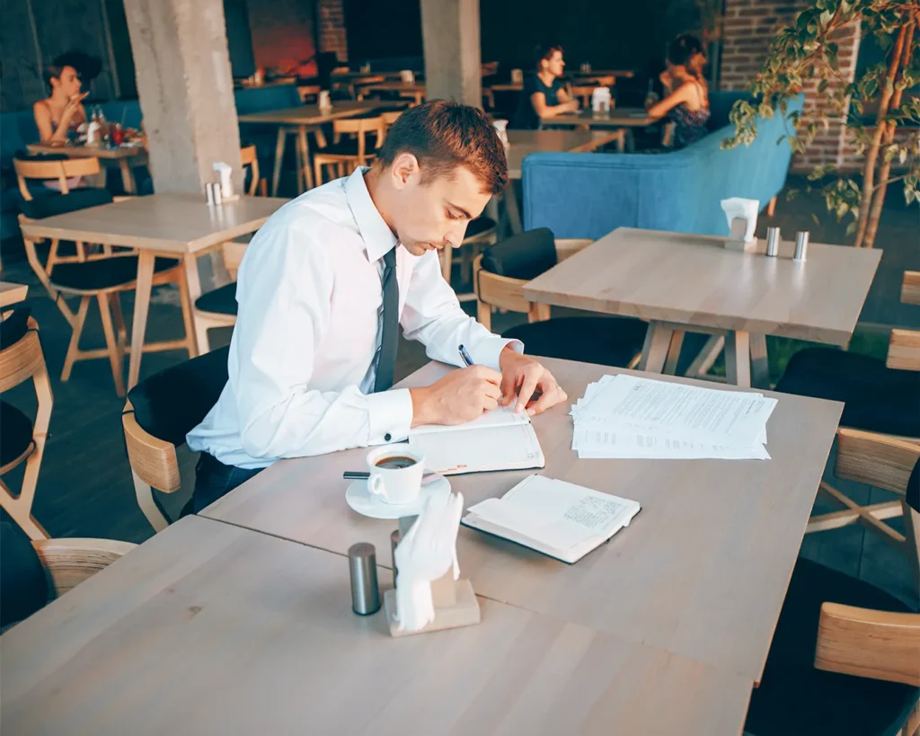 Restaurant manager reviewing guest retention reports and customer database in dining area