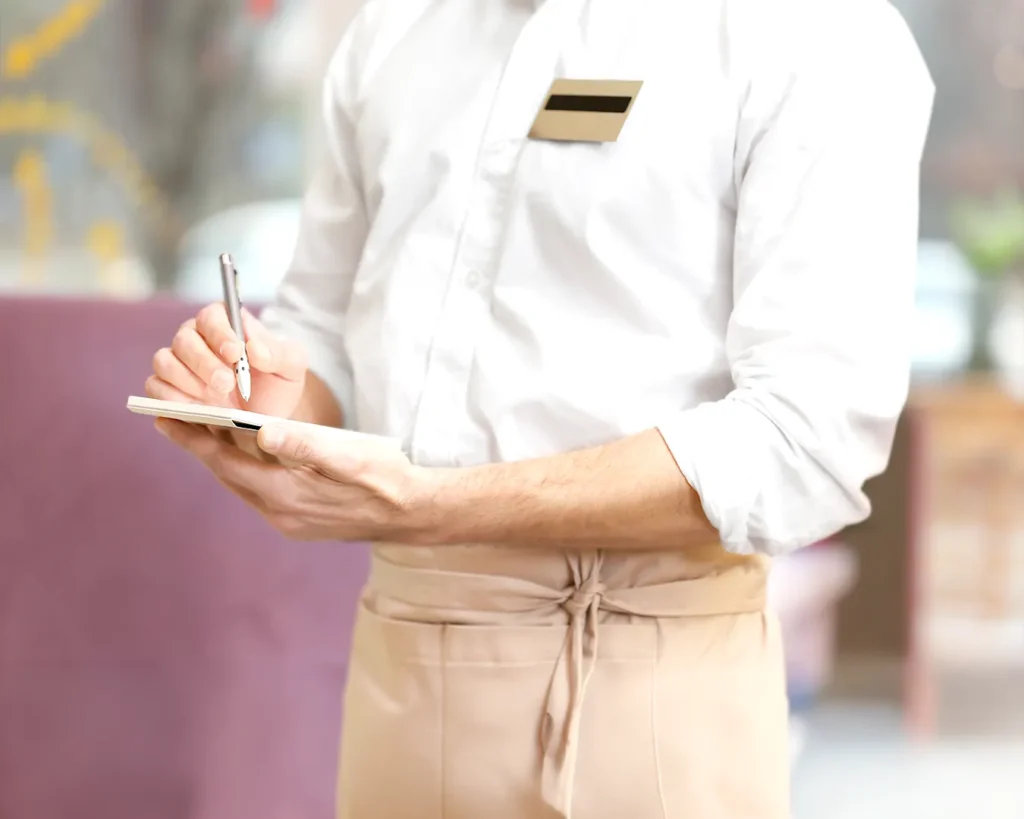 Restaurant staff checking reservation notes for birthday guests, supporting personalized service and automated reservation management.