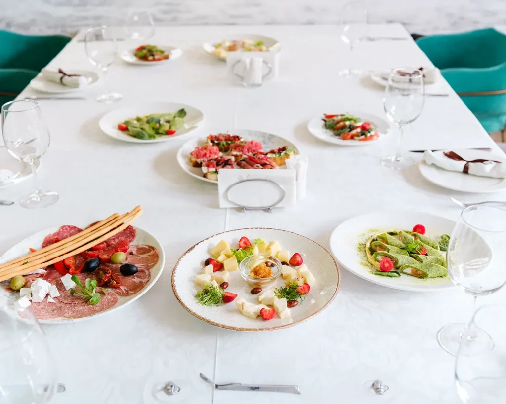 Restaurant table with appetizers and shared dishes, highlighting strategic menu design that encourages complete meal ordering and higher average spend.