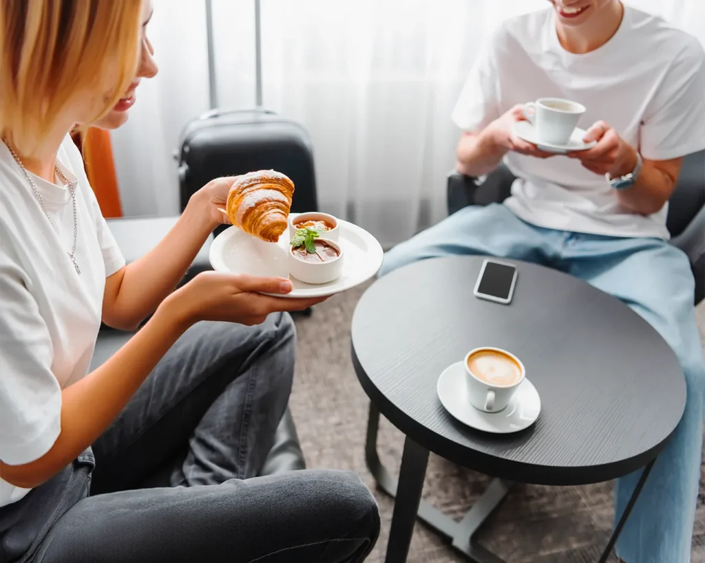 Friends sharing coffee and pastries in a cafe representing local food recommendations and word-of-mouth marketing