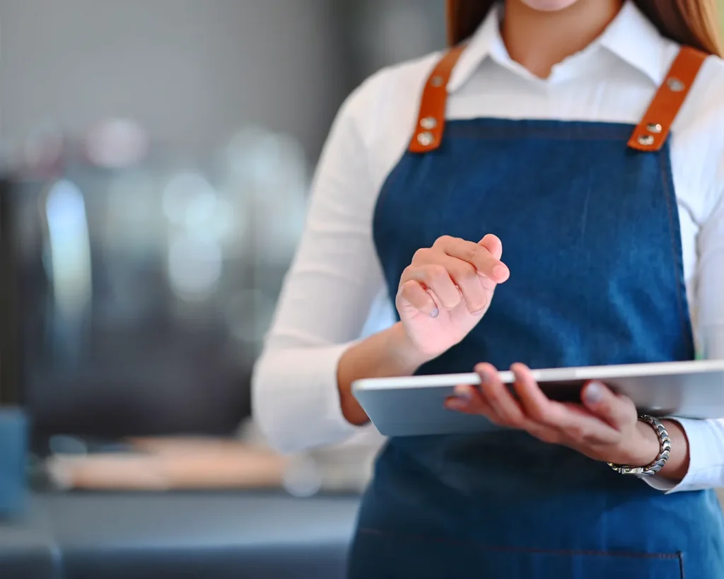 Restaurant staff managing online food delivery orders on tablet for digital restaurant operations