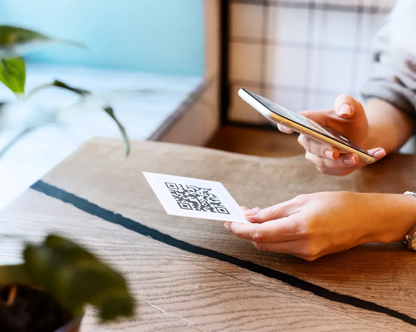 Guest scanning a QR code menu with smartphone at a restaurant table, showcasing contactless ordering and digital dining experience.