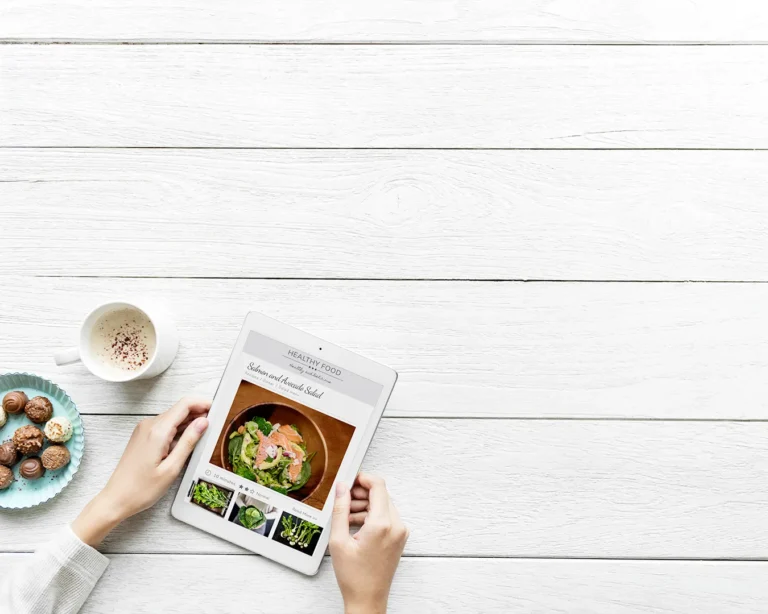 Food blogger using a tablet to view a healthy recipe and restaurant food content