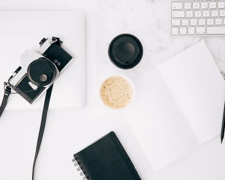 Restaurant influencer marketing planning with camera, laptop, and coffee