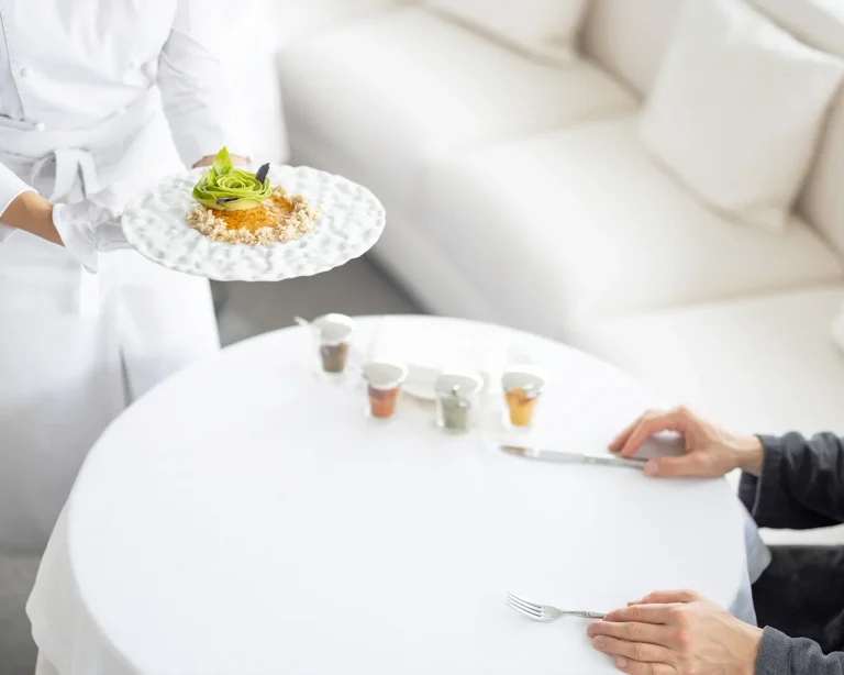 Fine dining waiter serving a beautifully plated dish