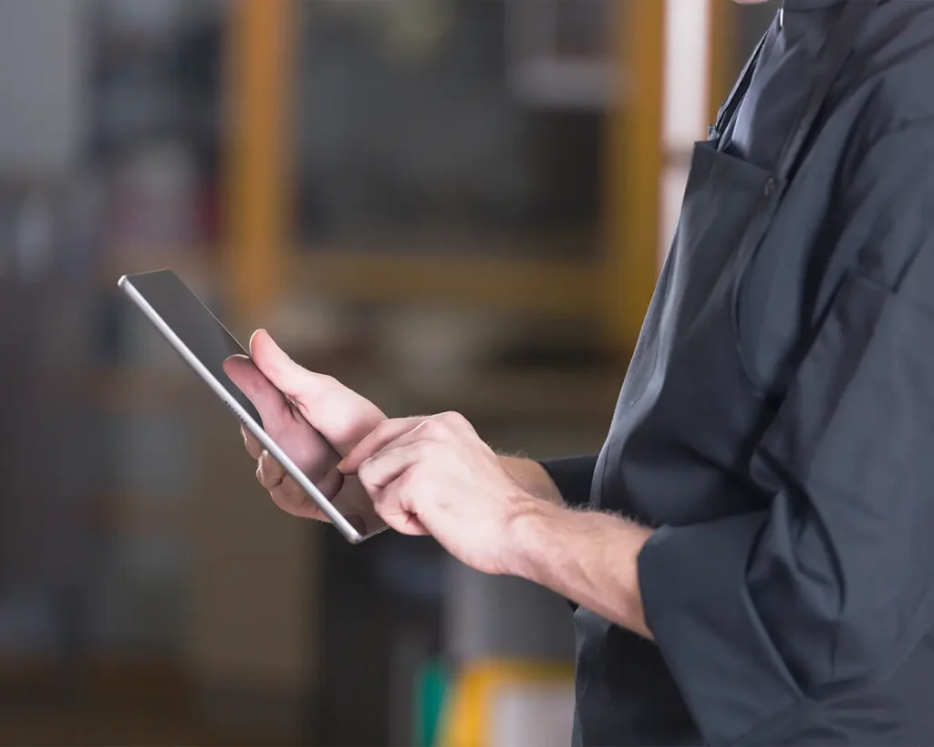 Restaurant worker using a tablet for cloud POS system management and digital operations