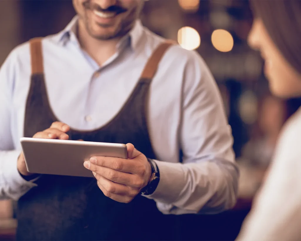Restaurant staff member using a tablet for digital customer service and restaurant management