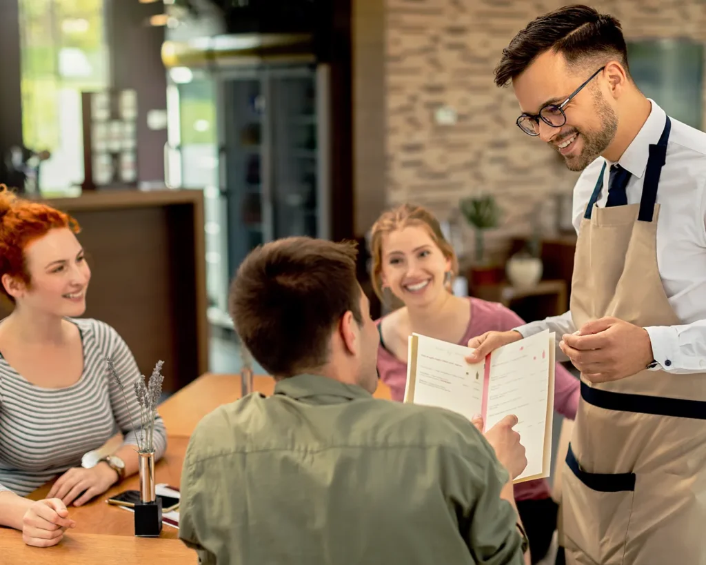 Restaurant server presenting a menu to customers during a dining experience