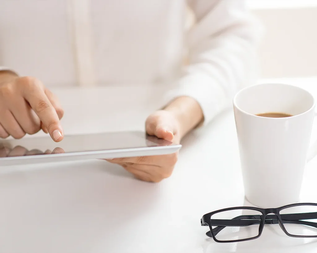 Restaurant guest browsing menu on tablet with coffee