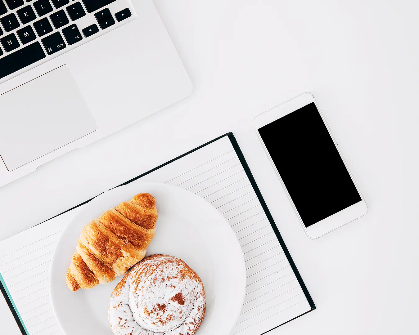 Restaurant business owner planning marketing strategy with laptop, phone, and café workspace
