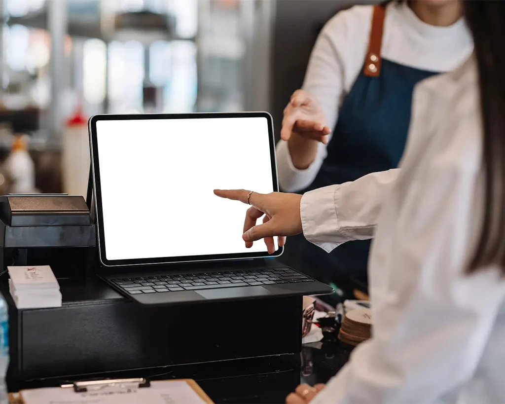 Restaurant staff demonstrating digital table ordering system on tablet at point of sale