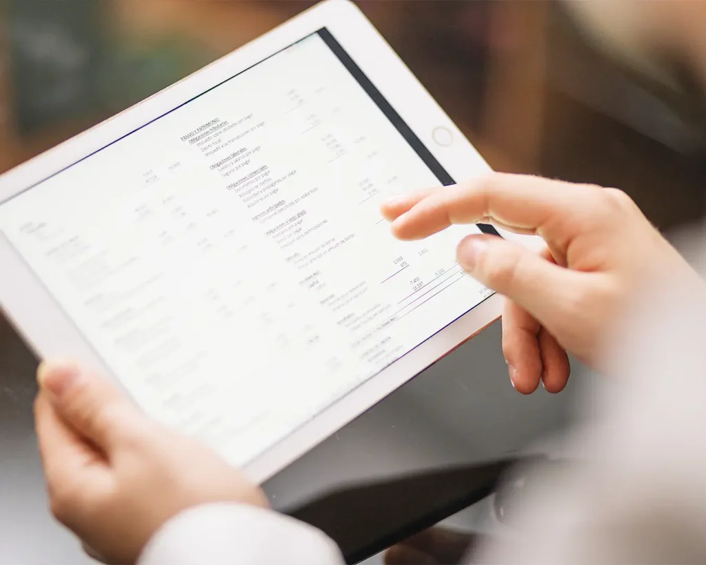 Business professional reviewing financial report and performance data on tablet