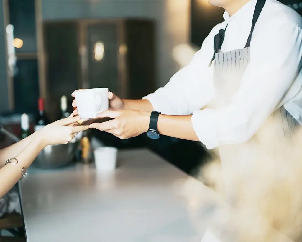 Restaurant server delivering coffee to a customer, highlighting personalized service and customer retention