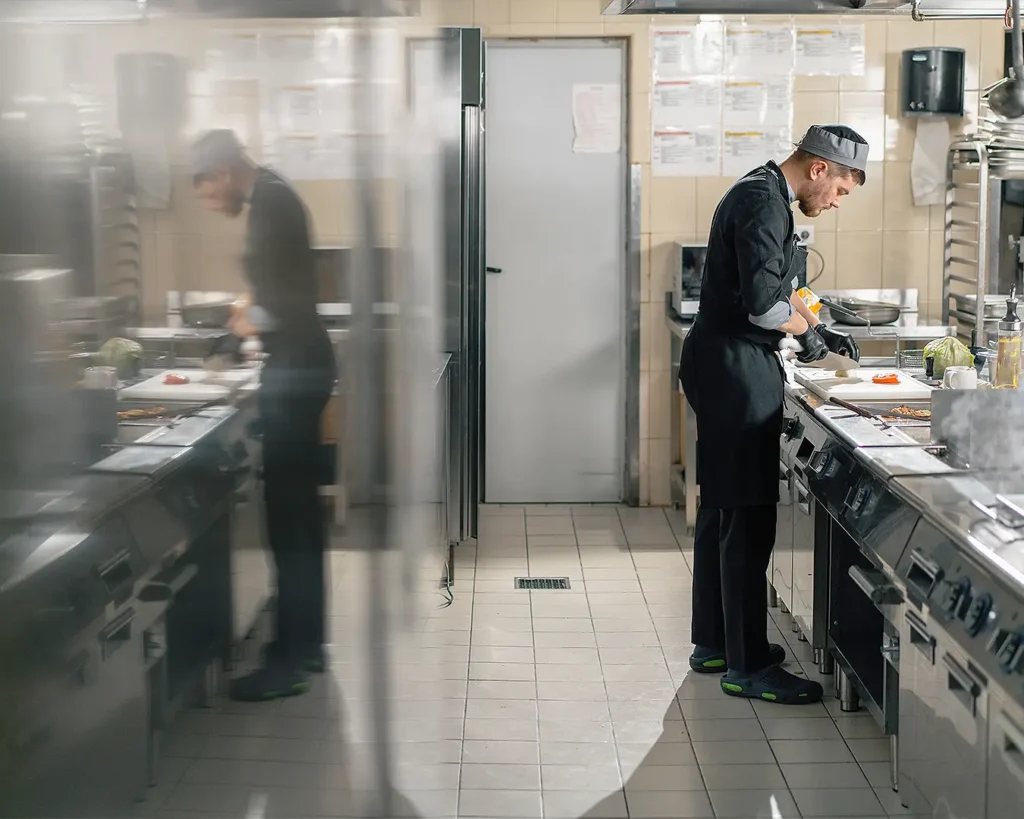 Restaurant chef working in a professional commercial kitchen during food preparation
