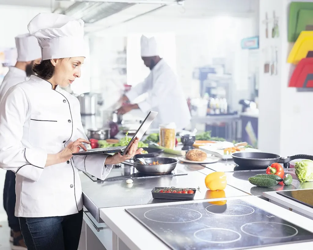 Restaurant chef using tablet to manage kitchen operations and maintain consistent food quality
