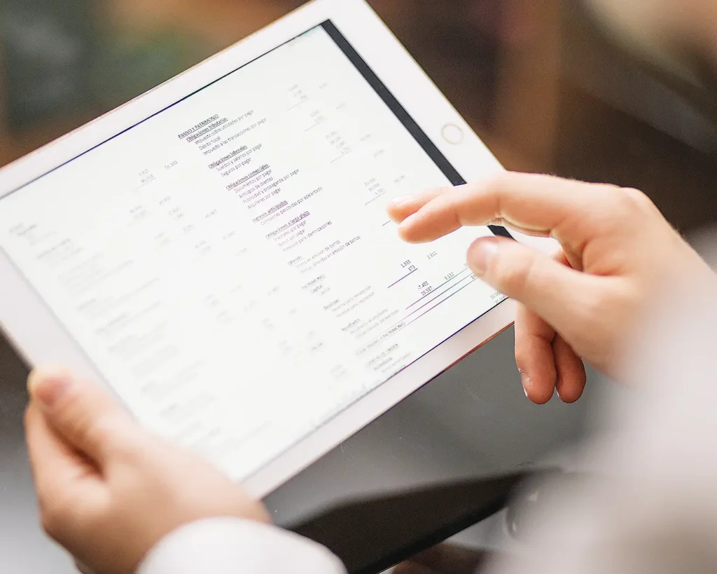 Restaurant owner reviewing customer data and engagement metrics on tablet for email and SMS marketing
