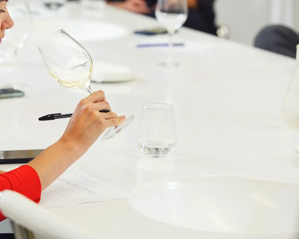 Restaurant professional evaluating wine quality and documenting food and beverage experience