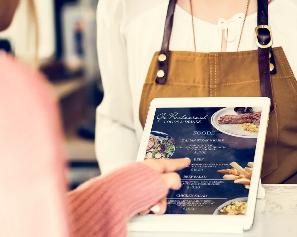 Customer reviewing a restaurant menu on a tablet with food and drink options