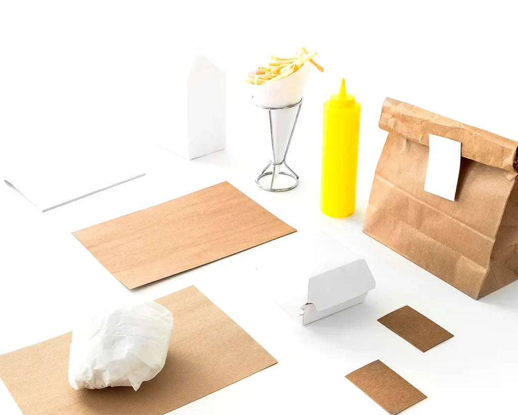 Minimal fast food packaging and kraft paper materials representing restaurant branding, packaging design, and colour consistency