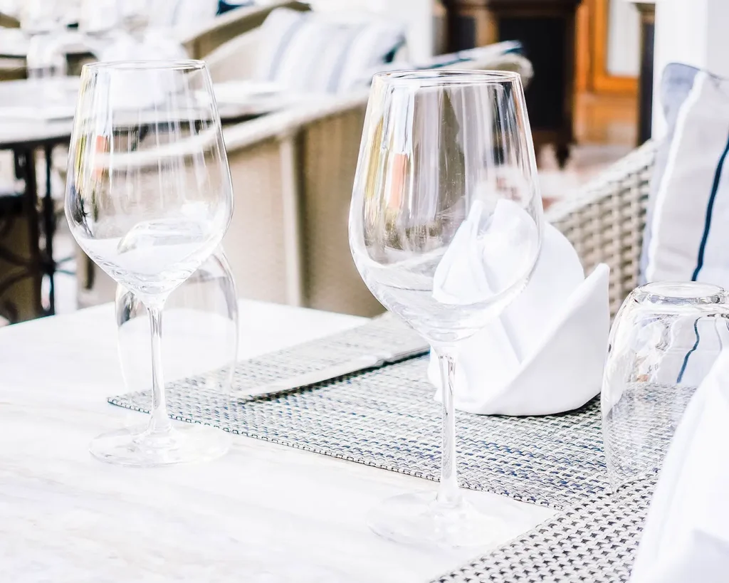 Elegant restaurant table setting with wine glasses and white linens representing a refined F&B brand identity and hospitality experience